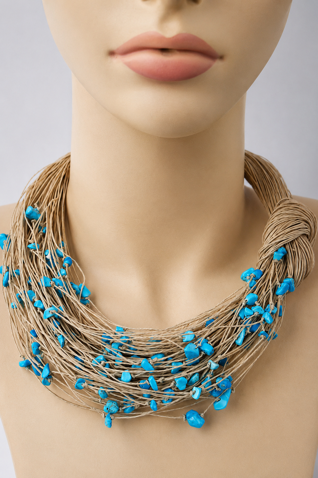 Multi-strand linen thread necklace with turquoise stone chips on a mannequin